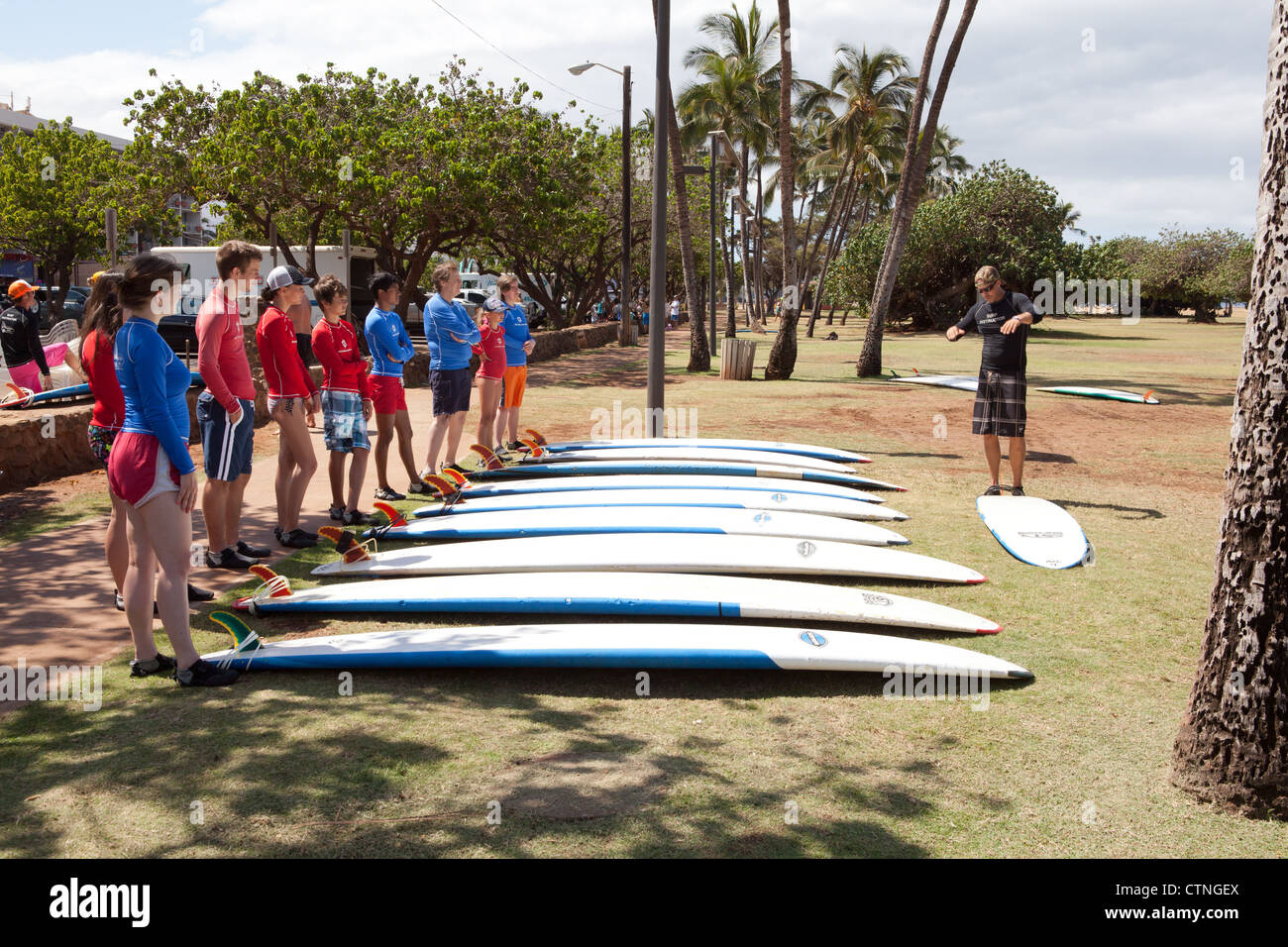 Surfing instructor teaching teens basic techniques in Maui, Hawaii