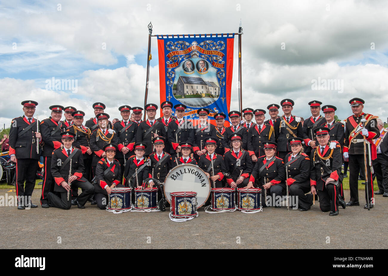 Ballygowan Flute Band pose for photograph in Ballynahinch Twelfth July Orange Parade, behind is the banner of Ballygowan Church Stock Photo