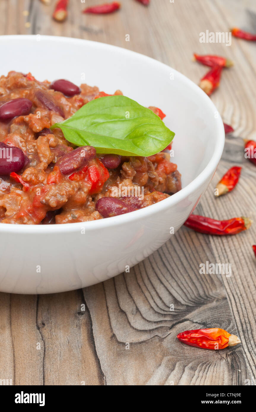 Chilli Con Carne in White Bowl and Red Chili Peppers Stock Photo