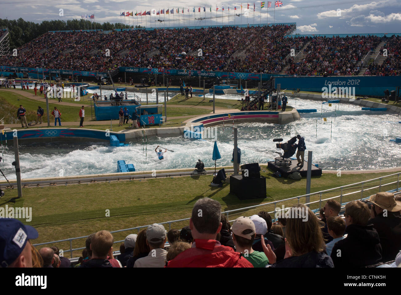 Wide view of the canoe slalom at the Lee Valley White Water Centre, north east London, on day 3 of the London 2012 Olympic Games. The Lee Valley White Water Centre is located 30 kilometres north of the Olympic Park, on the edge of the 1,000-acre River Lee Country Park – part of the Lee Valley Regional Park. The centre has two separate courses: a 300 metre Olympic-standard competition course with a 5.5m descent, and a 160m intermediate/training course with a 1.6m descent (more in description..) Stock Photo