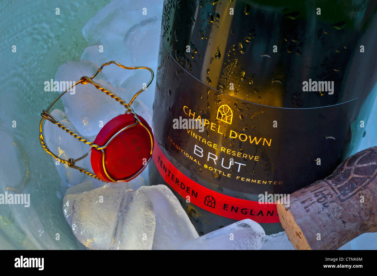 English sparkling wine 'Chapel Down Brut'  bottle on ice in wine cooler with cork and retaining cap Stock Photo