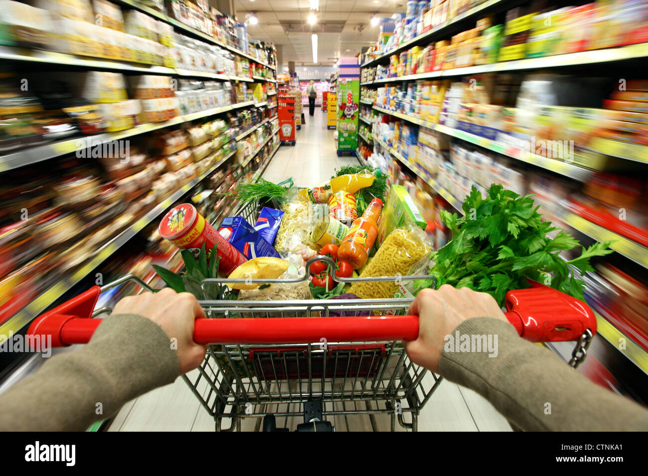 Food hall, full shopping trolley is pushed through a hallway with