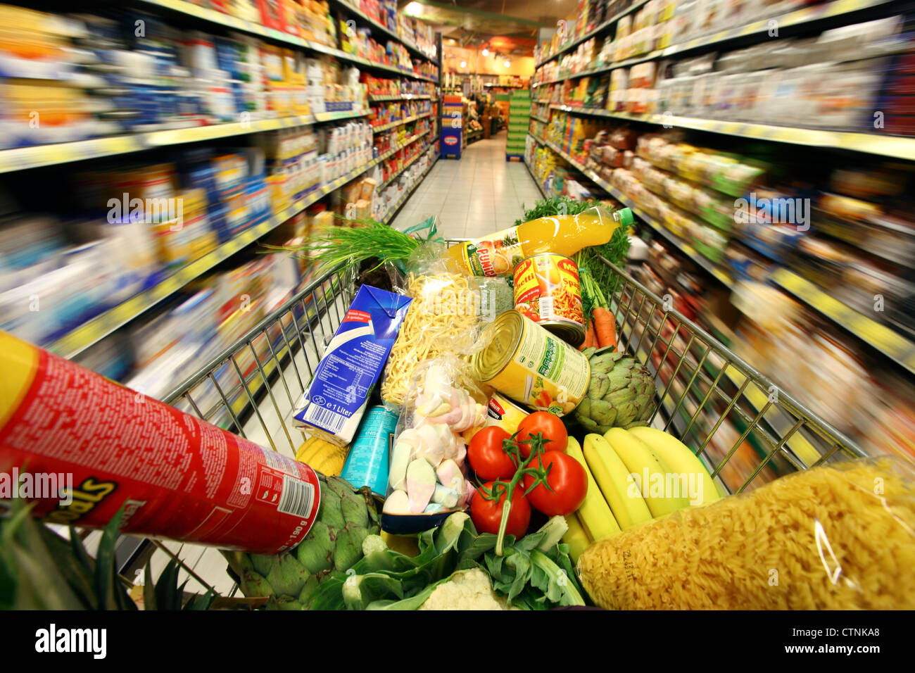 Food hall, full shopping trolley is pushed through a hallway with