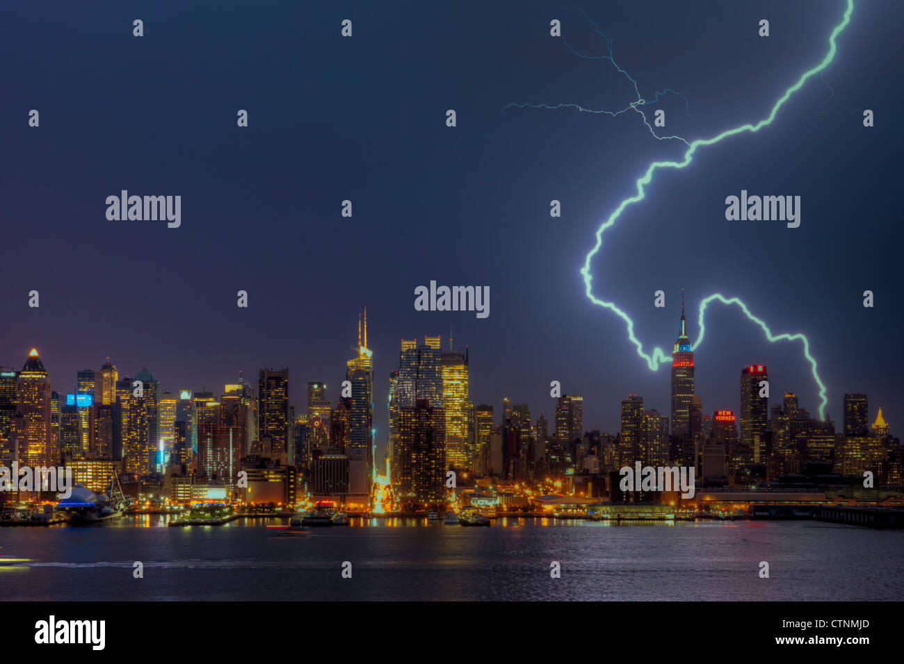 A large cloud to ground forked lightning bolt strikes the ground during a summer thunderstorm in New York City. Stock Photo