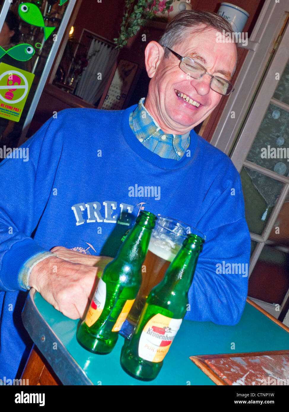 Man in bar drinking beer and laughing - France. Stock Photo
