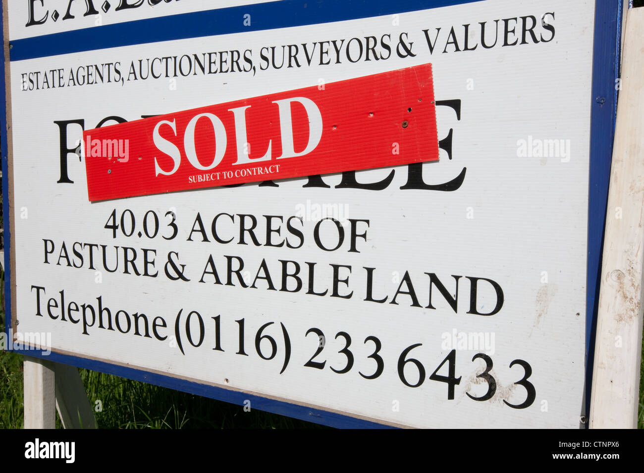 Agricultural land for sale sign with a 'sold' sticker on it Stock Photo