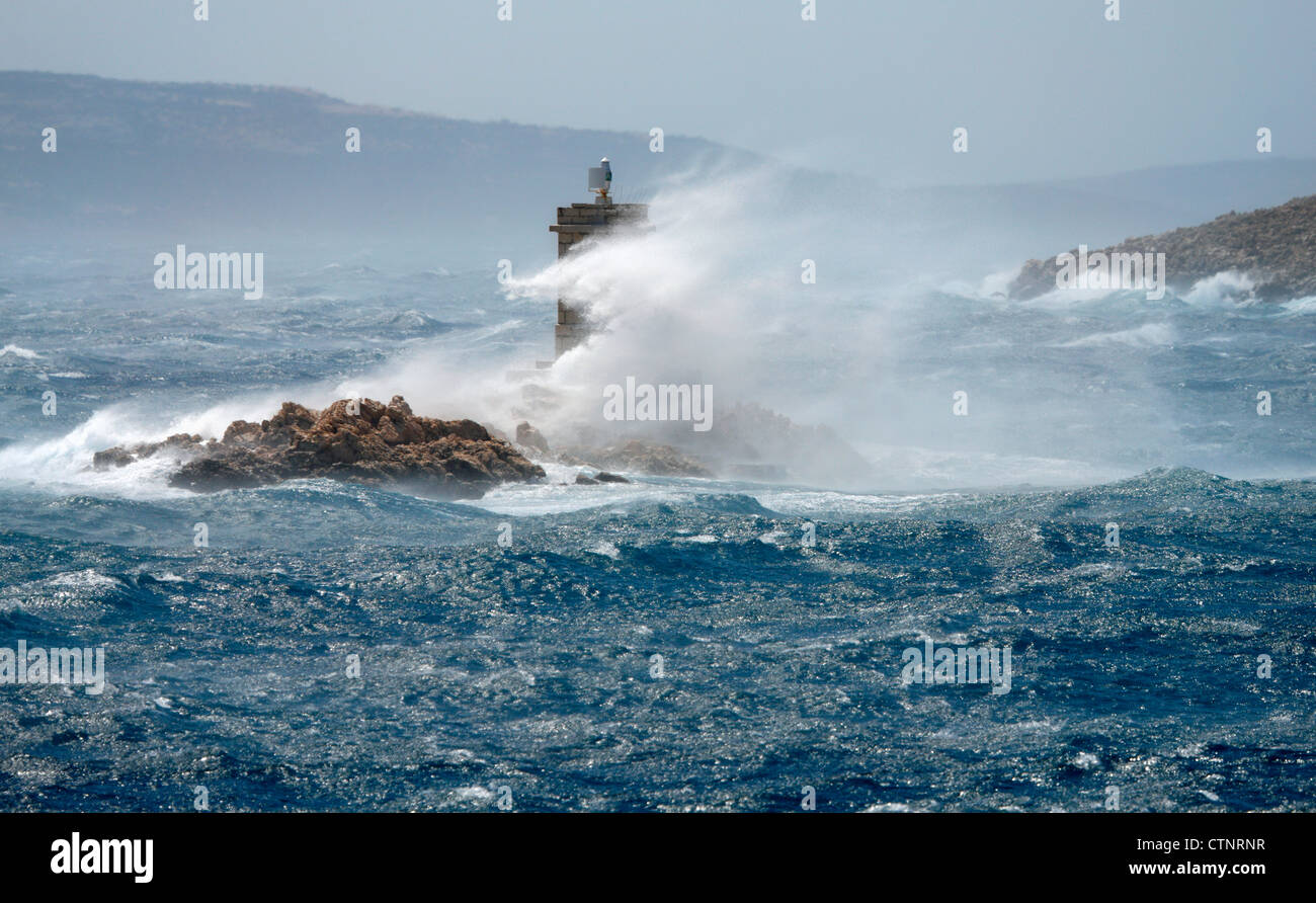 Waves break over the lighthouse near island Rab in Croatia Stock Photo