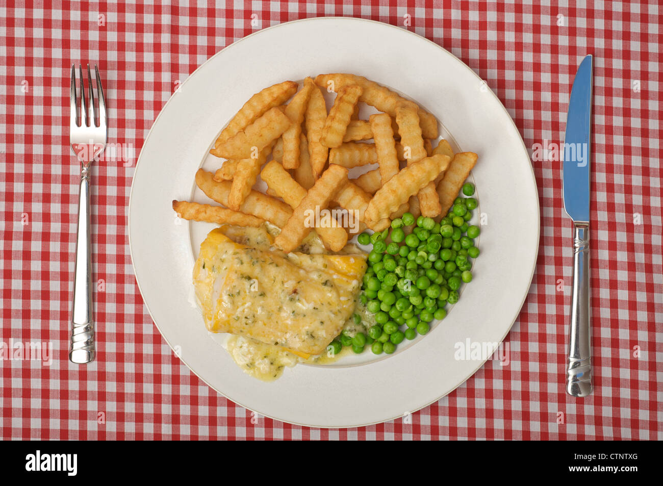 The Saucy Fish Co. Davidstow cheddar and chive sauce on smoked Haddock, chips and peas Stock Photo