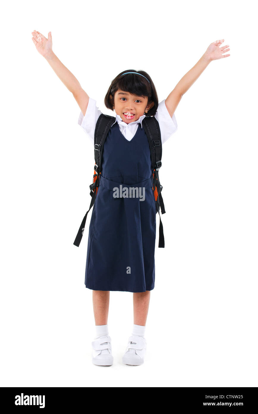 Six years old Southeast Asian school girl arms up in the air, fullbody over white background Stock Photo
