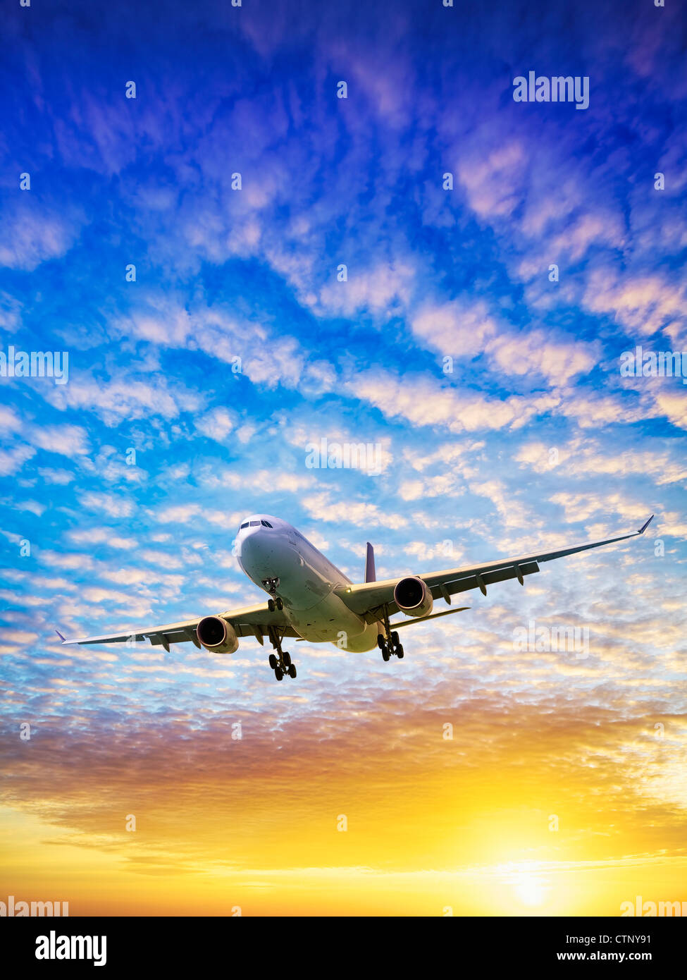 Jet in a sunset sky. Vertical shot. Stock Photo