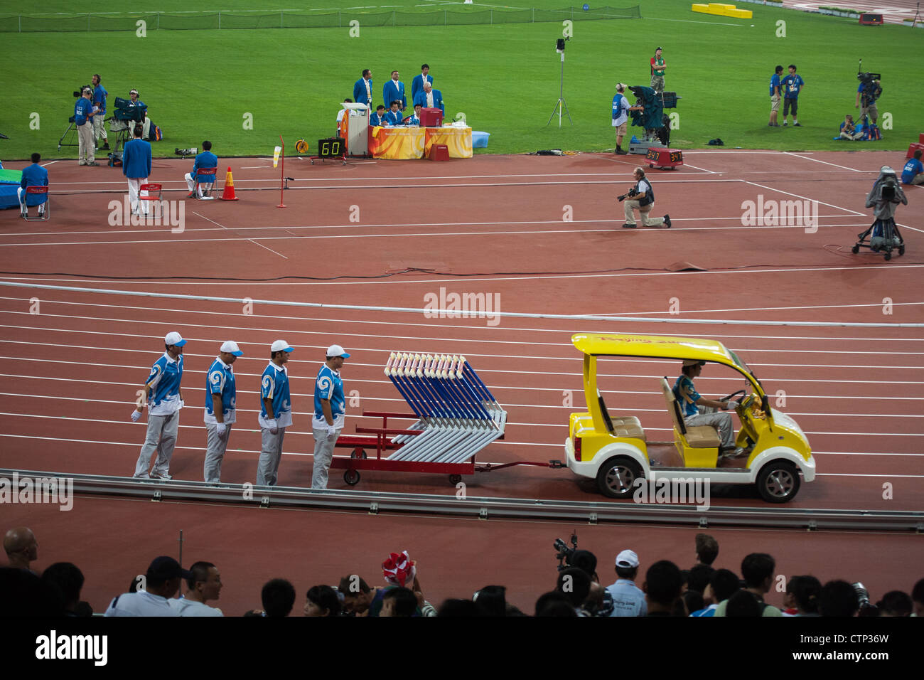 BEIJING, CHINA - AUGUST 16, 2008: Field crew sets up hurdles for track and field events in Birds Nest Stadium 2008 Summer Games Stock Photo