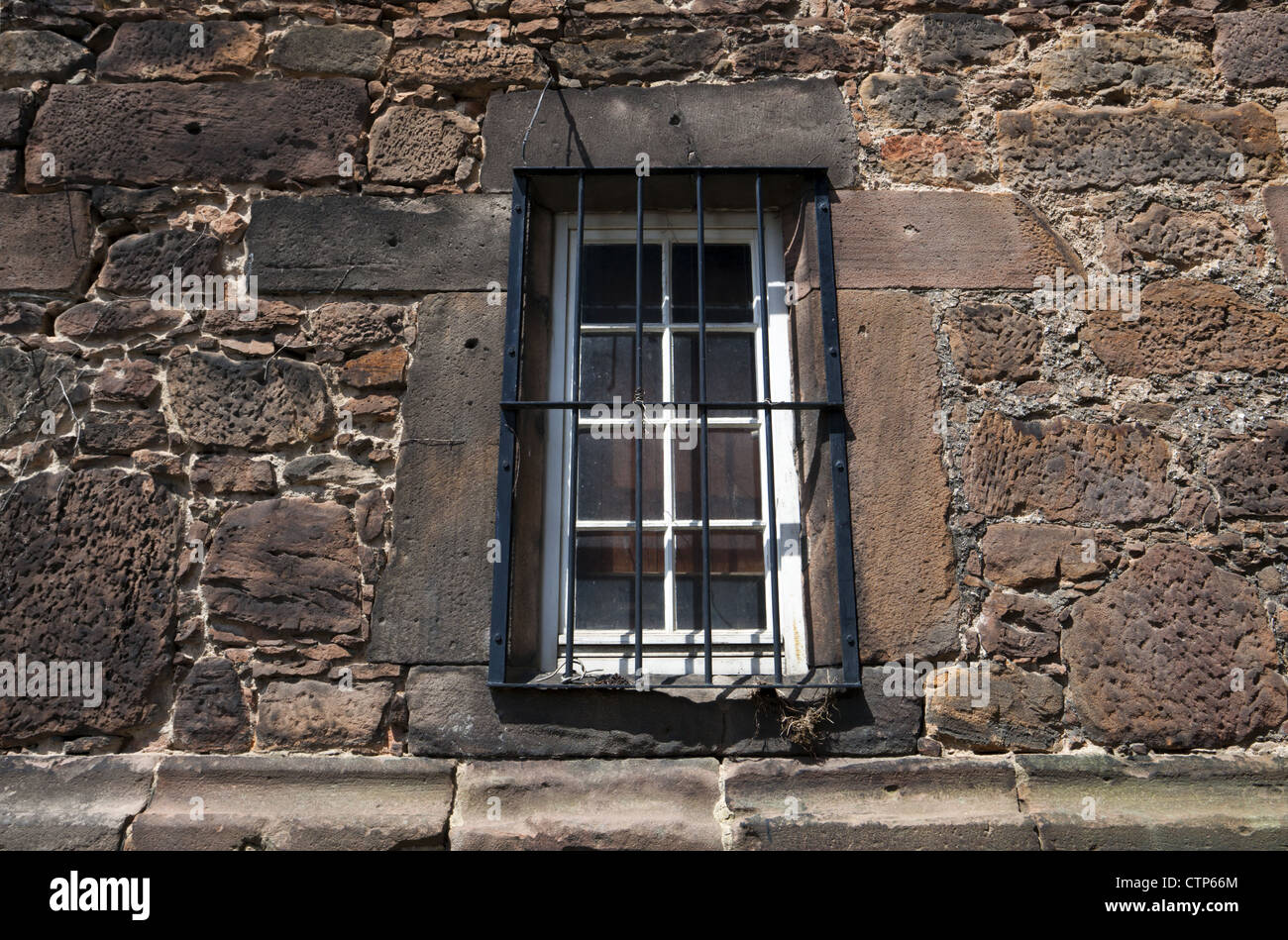 window with bars on stone wall Stock Photo