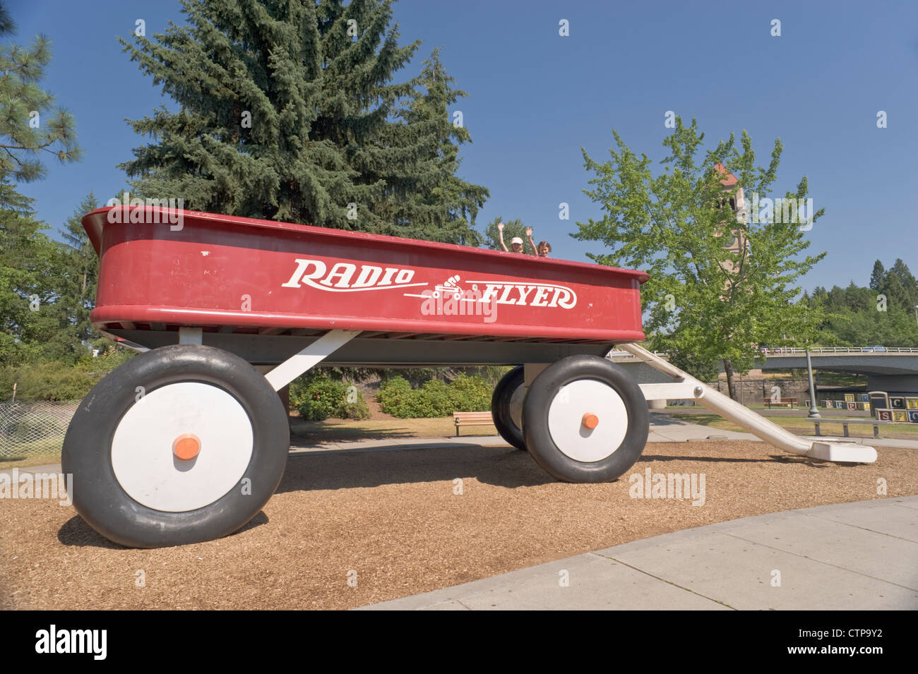 Children wave from atop the giant, red, Radio Flyer wagon at Riverfront