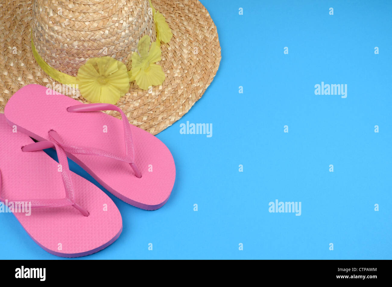 Sun hat and flip-flops on a blue background Stock Photo - Alamy