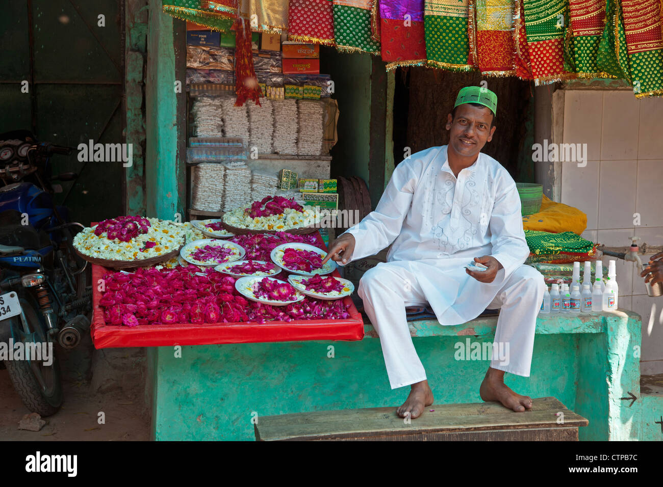 Vendor in front of shop selling scarfs and flowers as gifts for offerings near the Nizam-Ud-Din shrine in Delhi, India Stock Photo