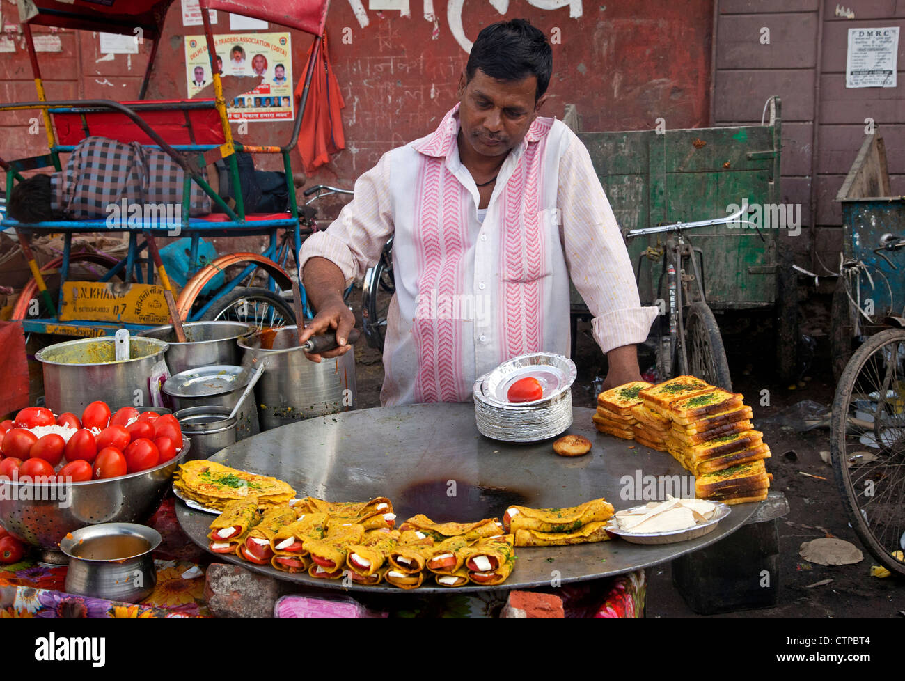 Man cooking food on huge frying pan in the street in Old Delhi, India