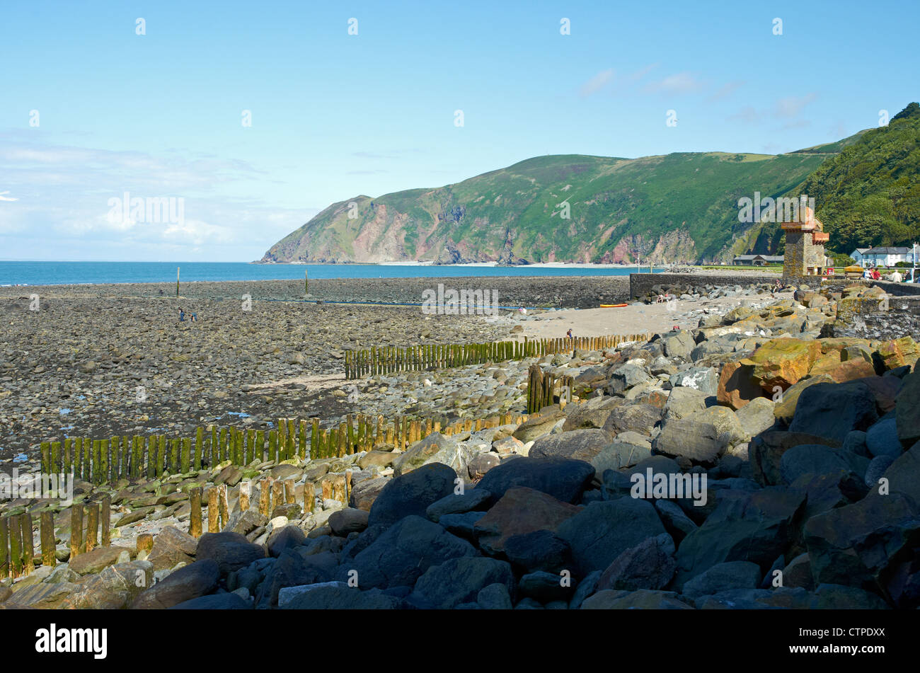 Beach at Lynton, Devon showing rocky and stony nature with steep Old Red Sandstone cliffs and Exmoor moorland from Lynmouth. Stock Photo