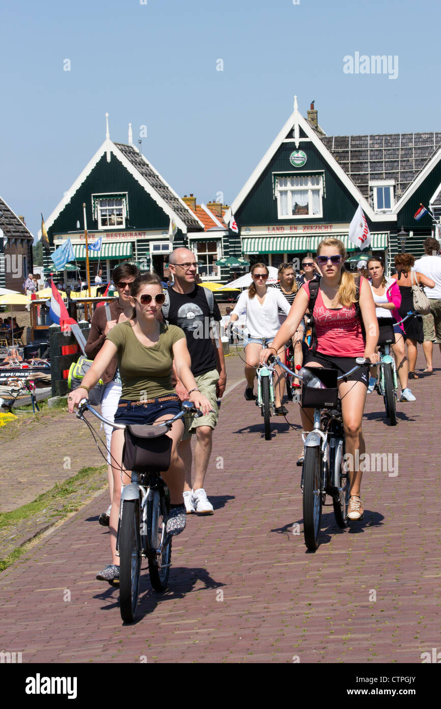 Girls cycling through the touristic town of Marken, The Netherlands Stock Photo
