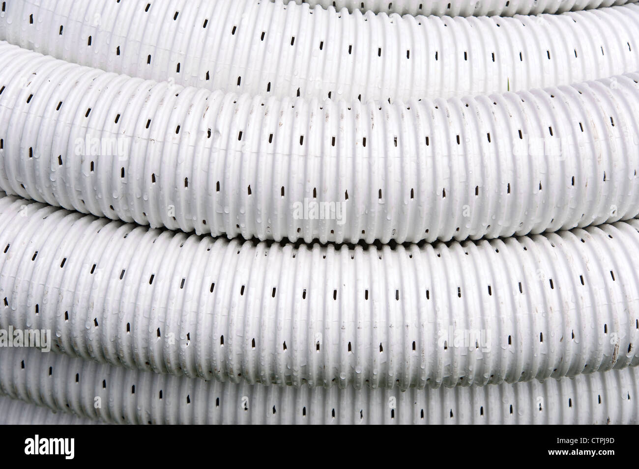 Perforated, flexible plastic piping used for land drainage Stock Photo
