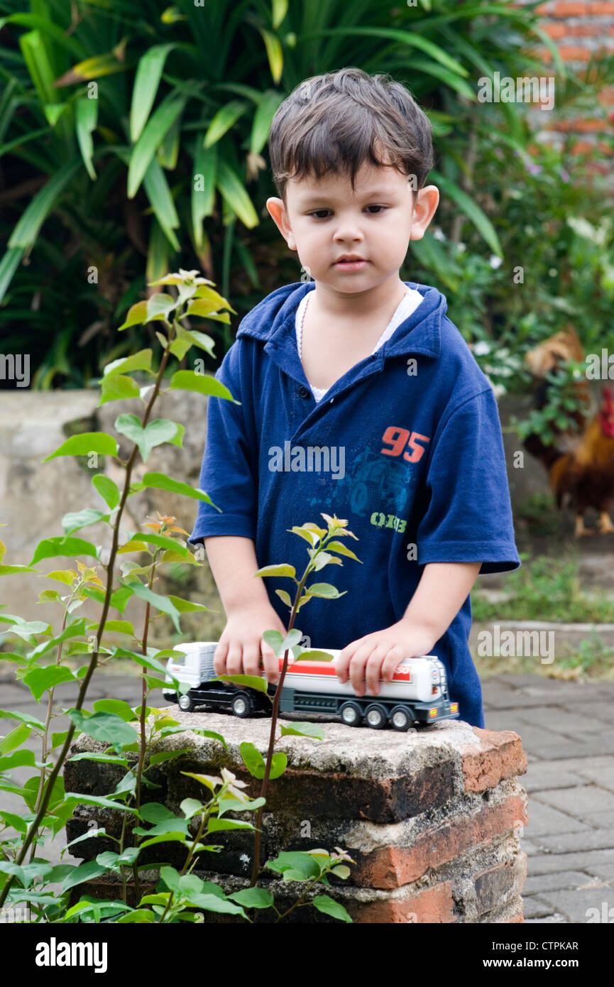 little boy playing with his toy cars in garden Stock Photo - Alamy