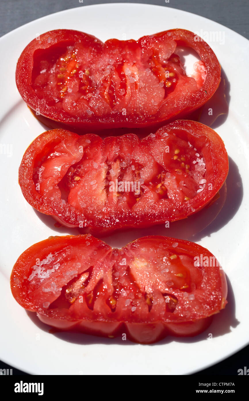 Slices of Pink Beef or Zapotec Pleated Tomato with Sea Salt Stock Photo