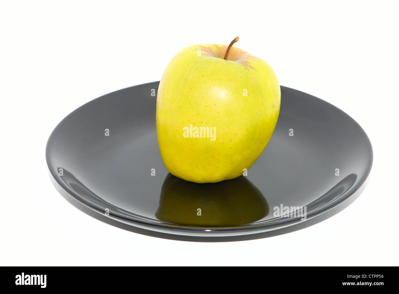 Green apple on the black plate Stock Photo