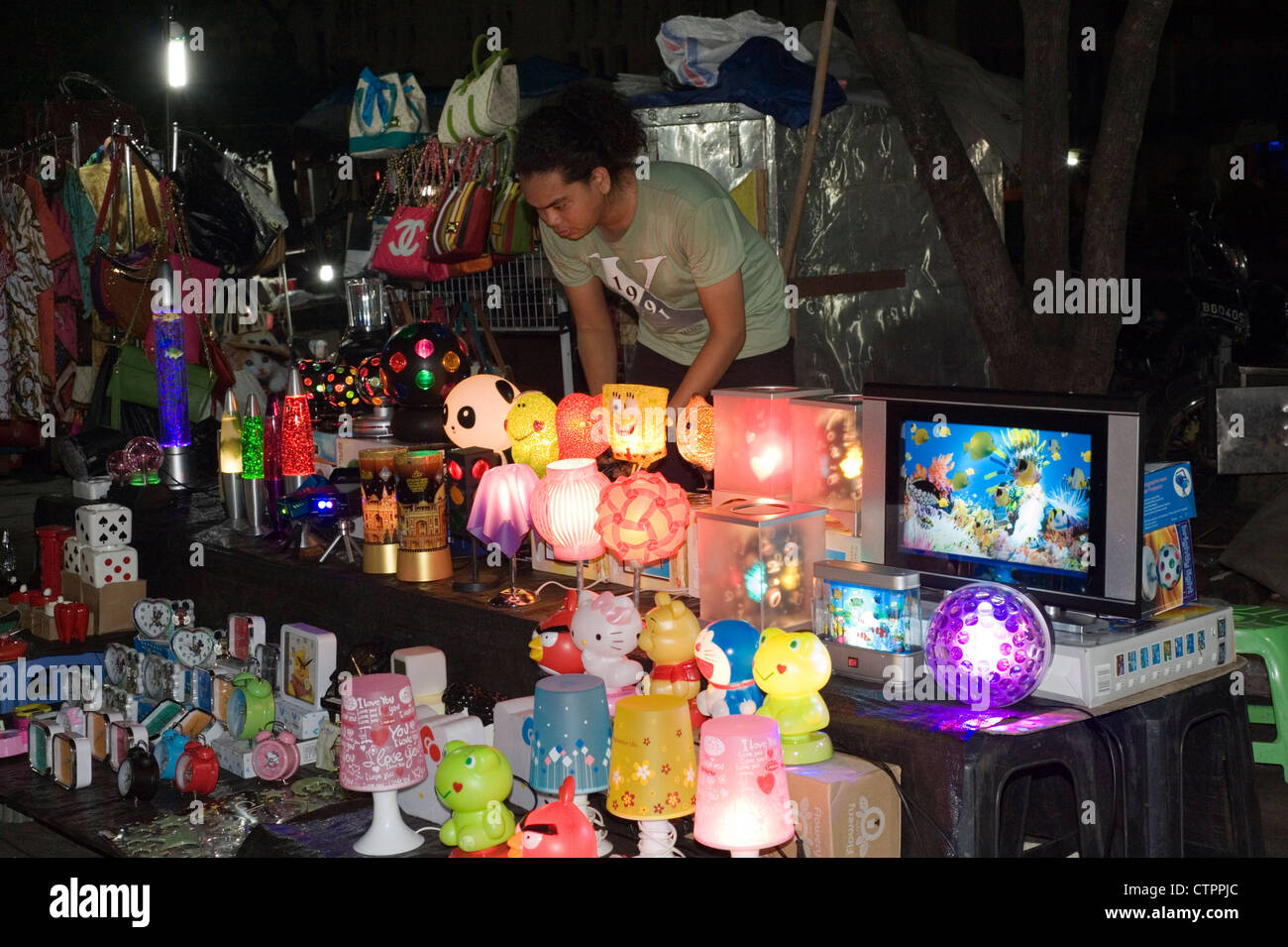 local woman selling electronic goods at the night market batavia old town jakarta java indonesia Stock Photo