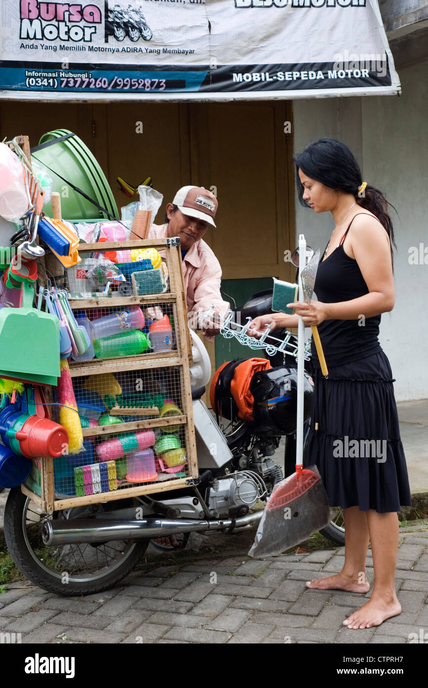 local village woman buying household items from street vendor java indonesia Stock Photo