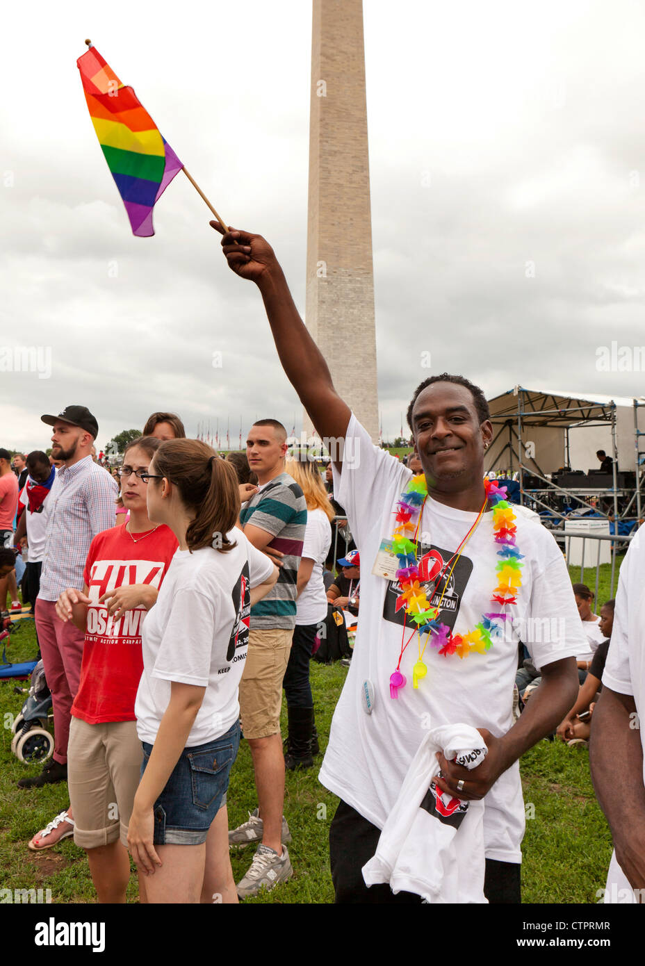 A man waves a rainbow flag in front of the Washington Monument during AIDS/HIV awareness march - July 22, 2012, Washington, DC USA Stock Photo