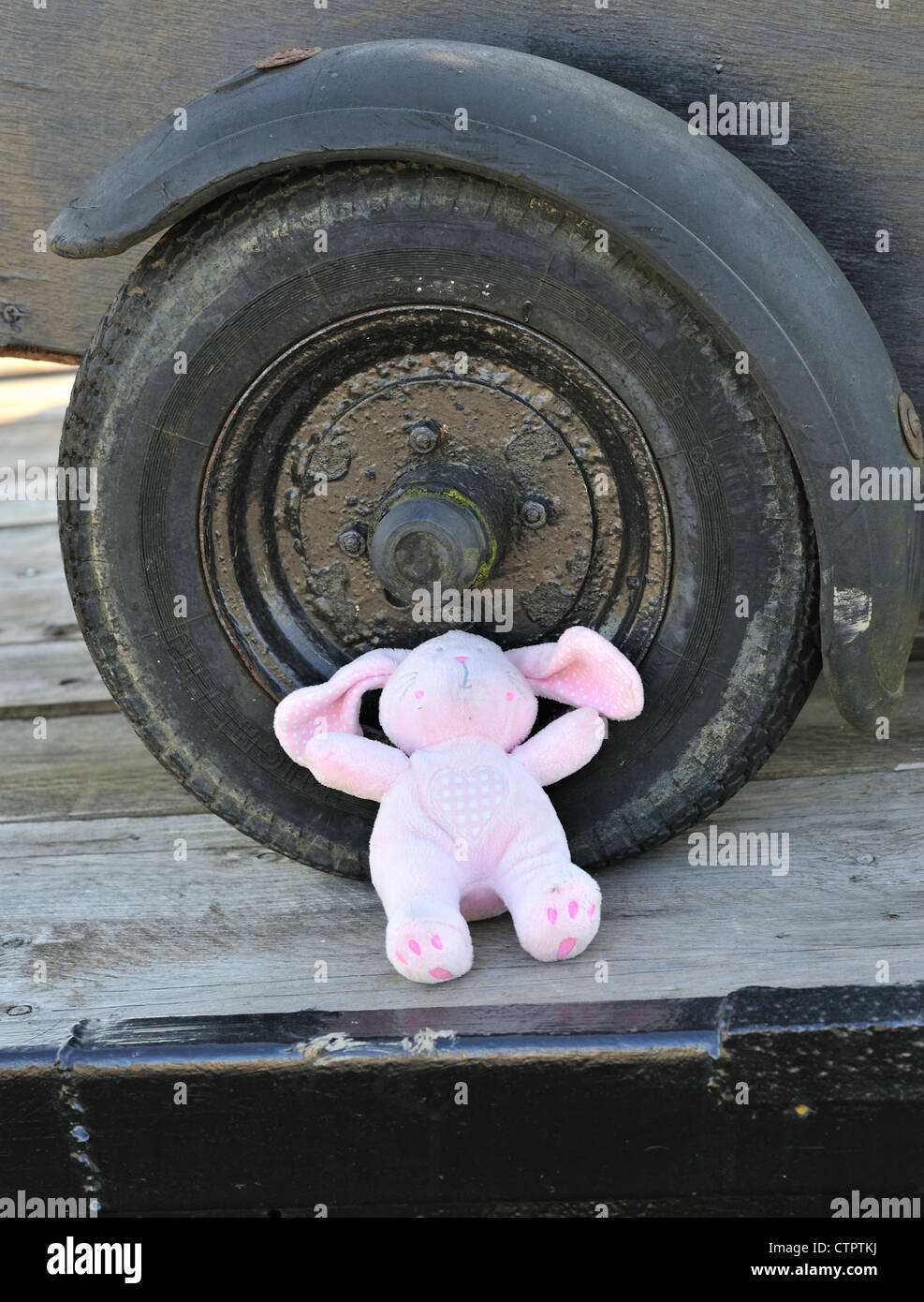 Lost toy resting against a car wheel Stock Photo