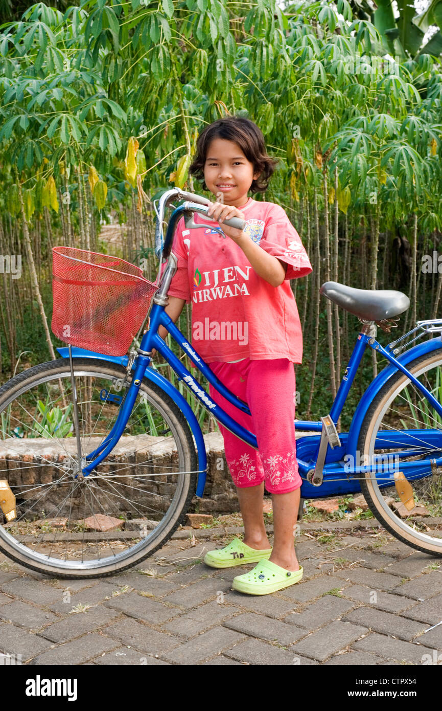 local villager young girl in rural village street with large traditional bicycle Stock Photo