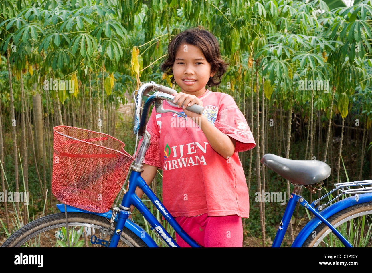 local villager young girl in rural village street with large traditional bicycle Stock Photo