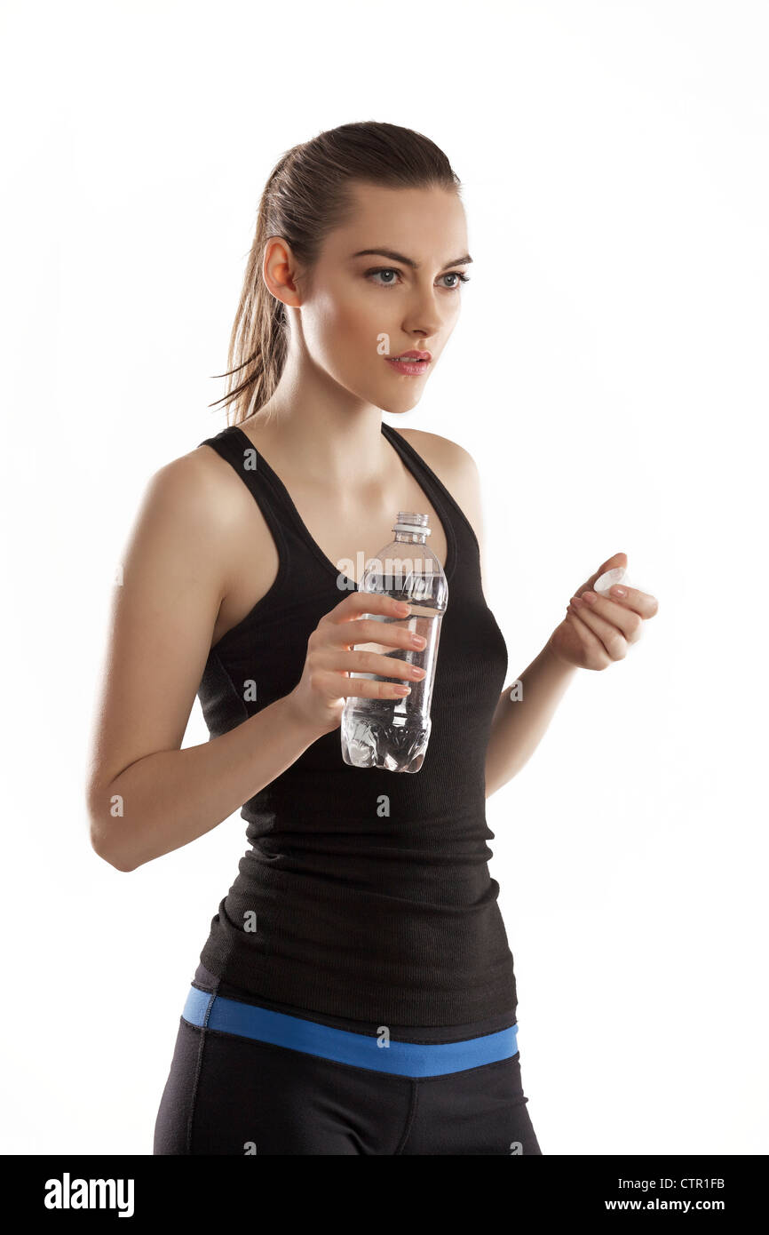 Young Caucasian woman drinking water after exercise Stock Photo