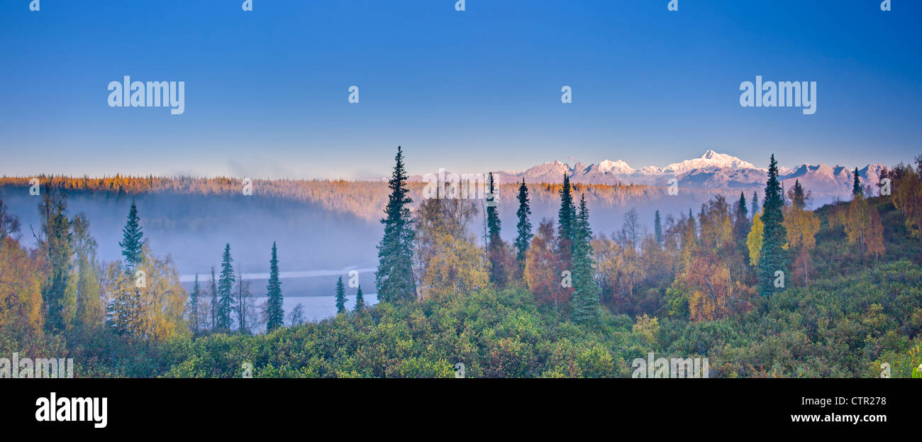 The early morning sun lights up Mount McKinley Alaska range as fog covers Chulitna River valley photographed Denali South Stock Photo