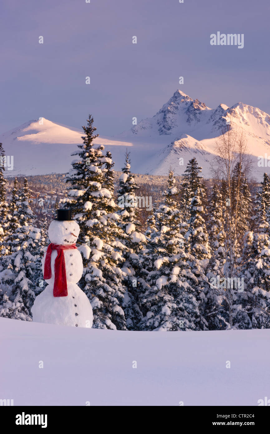 Scenic view Chugach Mountains snowman wearing scarf top hat in foreground Anchorage Southcentral Alaska Winter Stock Photo