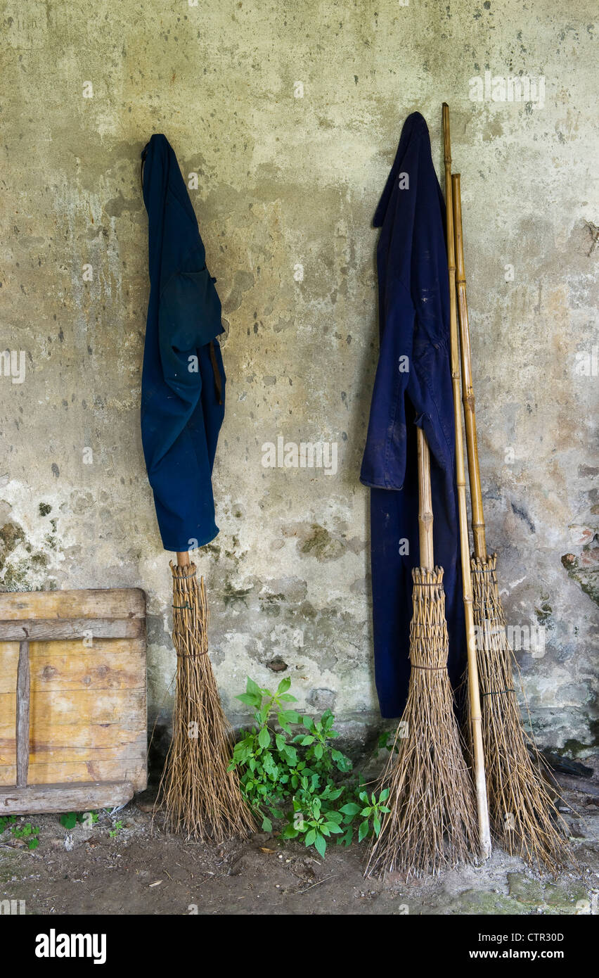 Gardeners' twig brooms stand ready for use in a garden in the Veneto, Italy Stock Photo