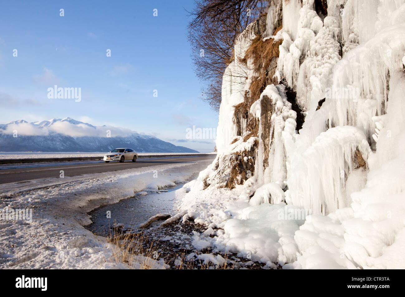Vehicle passes icy cliffs along Seward Highway, Southcentral Alaska, Winter Stock Photo