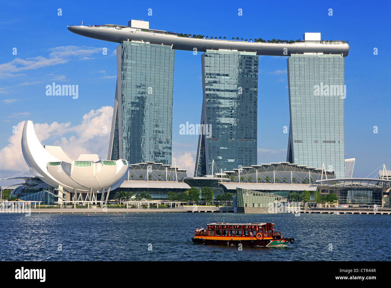 Traditional water taxi ferry and Marina Bay Sands and Skypark, luxury five star hotel, casino and shopping complex in Singapore. Stock Photo