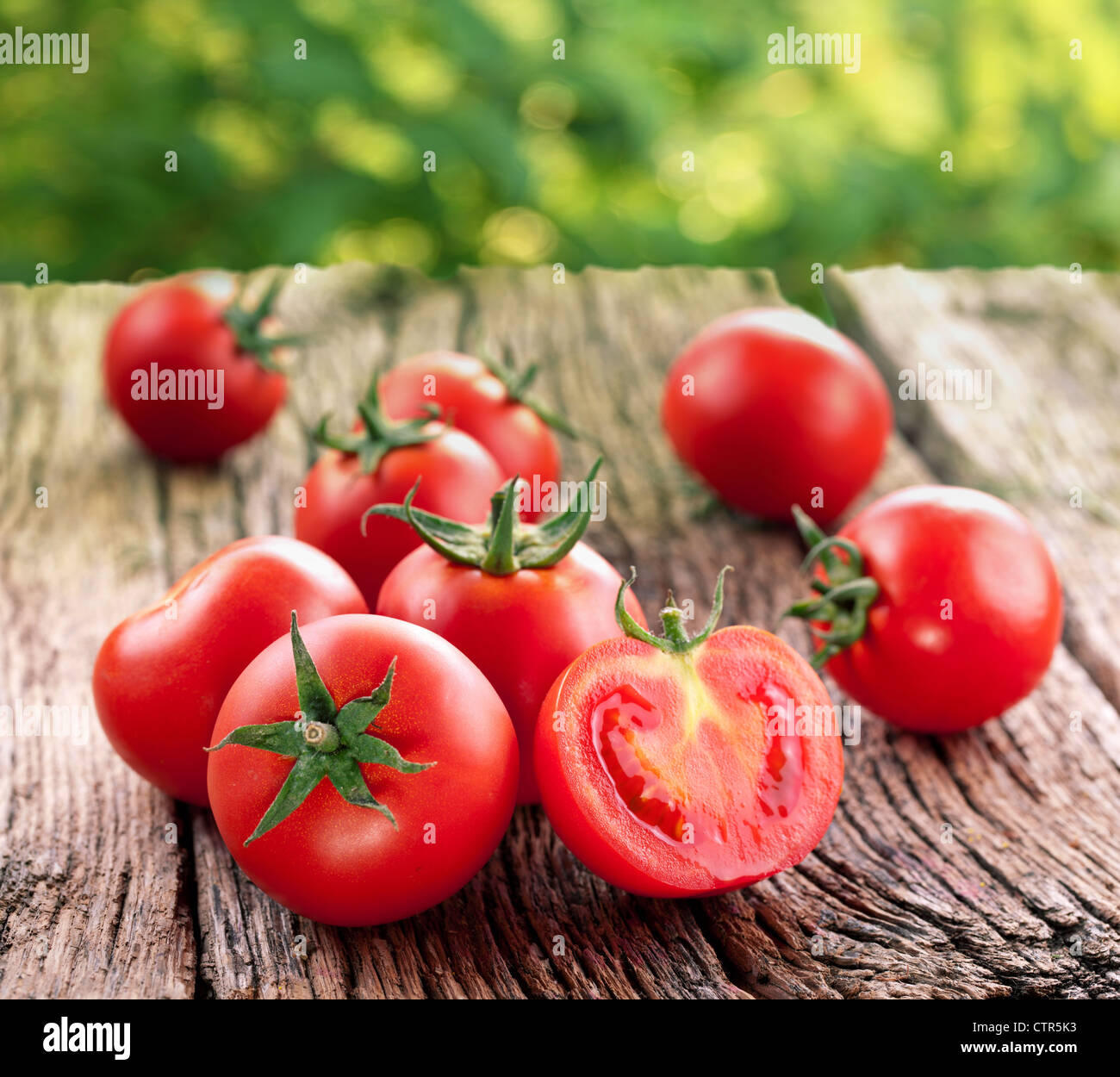 Tomatoes, cooked with herbs for the preservation on the old wooden table. Stock Photo