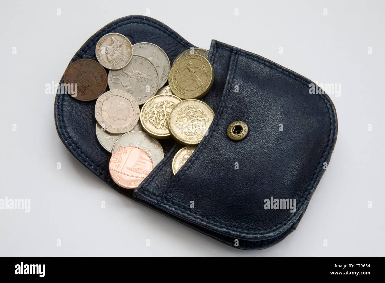Studio Sterling coins spilling out of a small blue purse Stock Photo ...