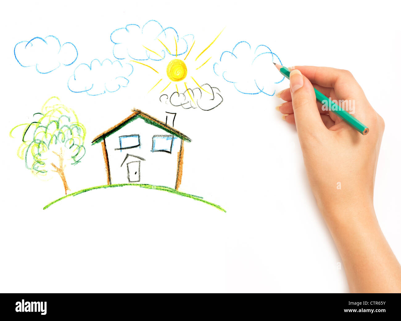 Wman's hand with the pencil drawing the dream home on a white sheet of paper Stock Photo