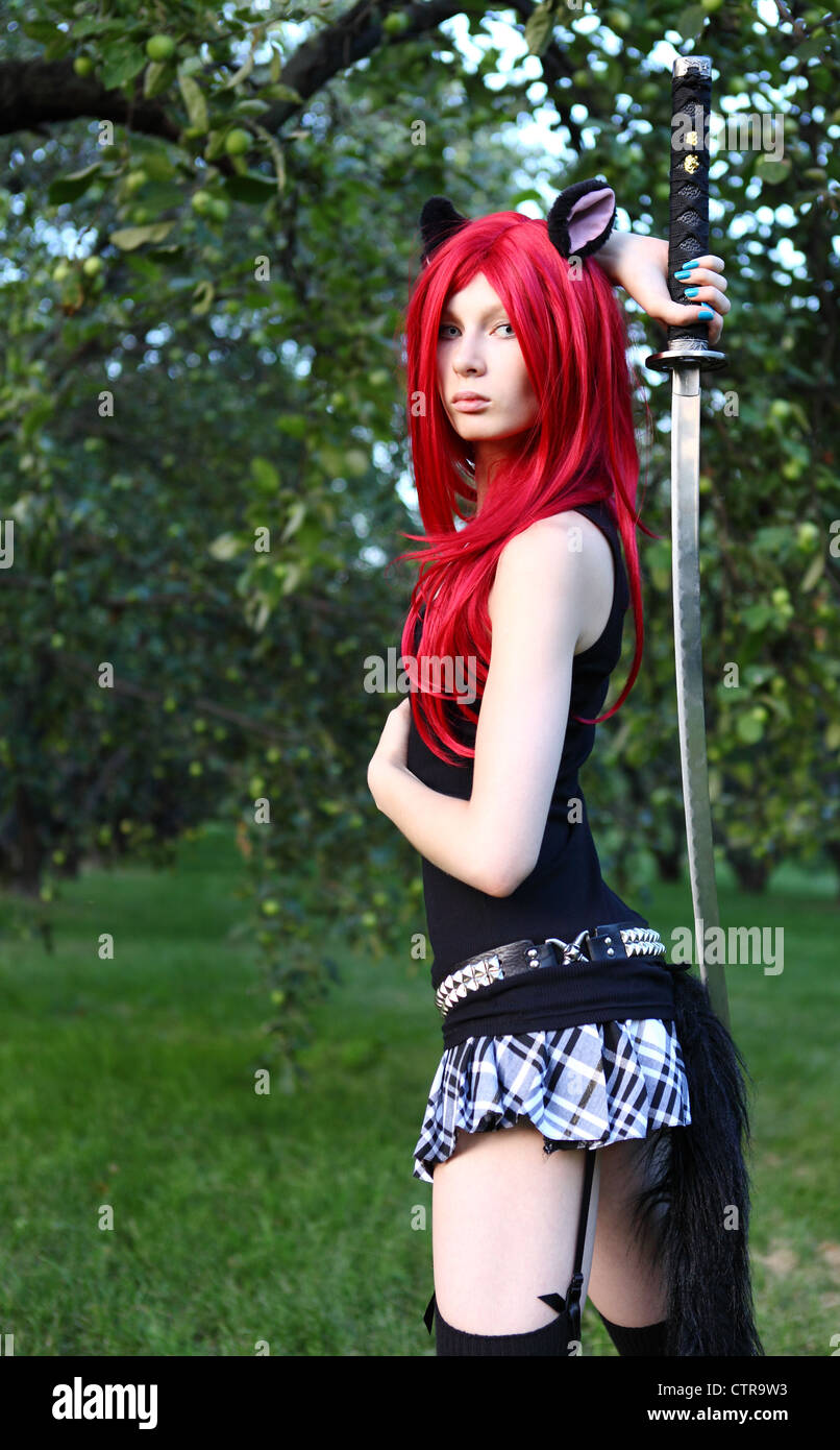 young girl in cat manga wear holding sword at the summer park Stock Photo
