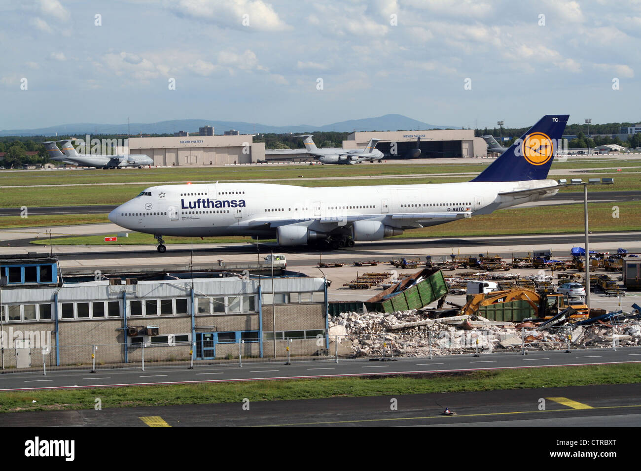 Lufthansa Airlines Boeing 747 at Frankfurt Airport. In the back US Air Force cargo planes at the now closed Rhein-Main Airbase Stock Photo