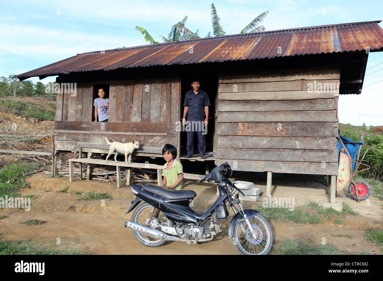 Family outside their simple dwelling high in the hills of Samosir Island, Lake Toba, North Sumatra. Stock Photo