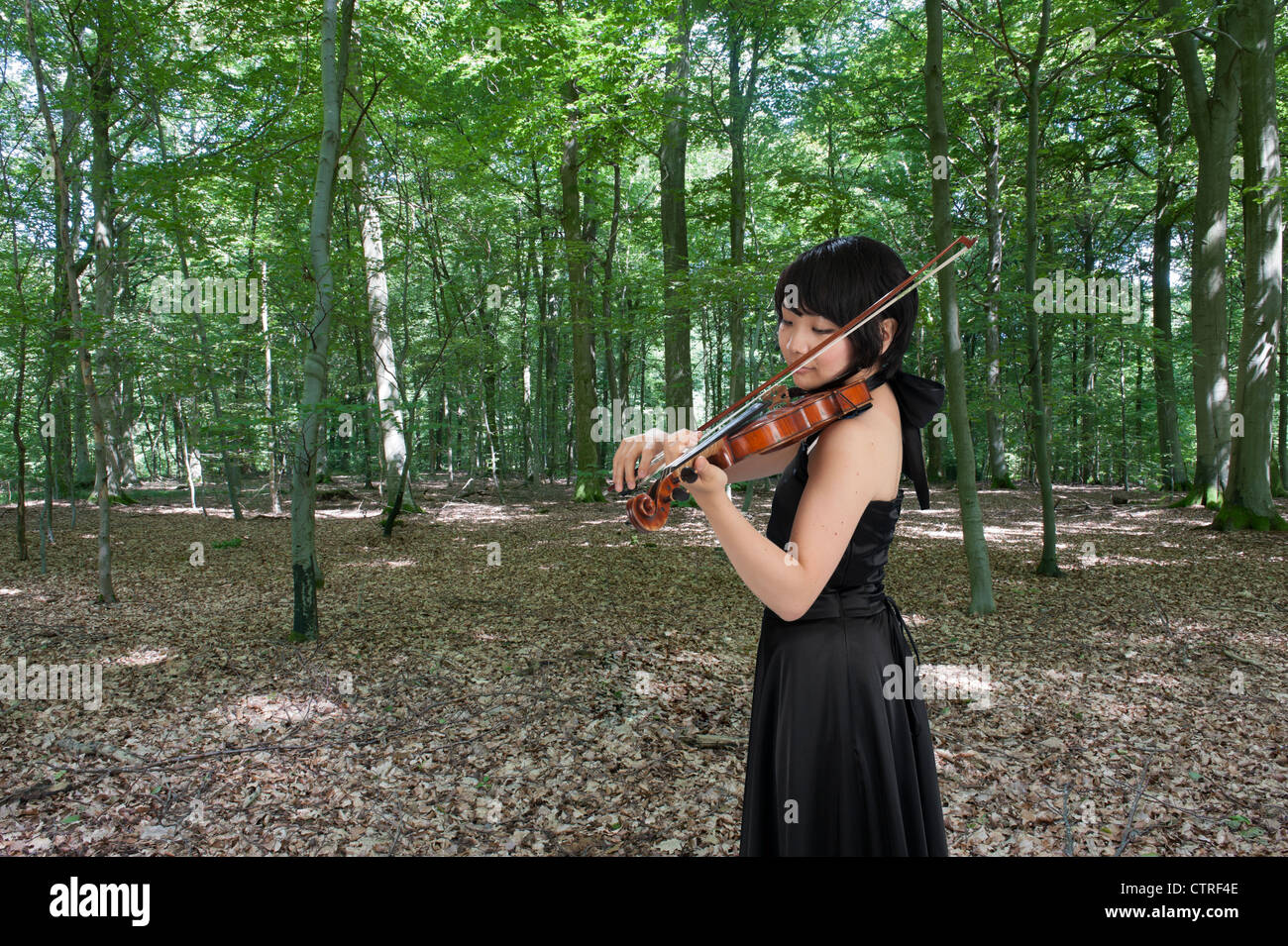 female asian violinist playing the violin in the forest Stock Photo Alamy