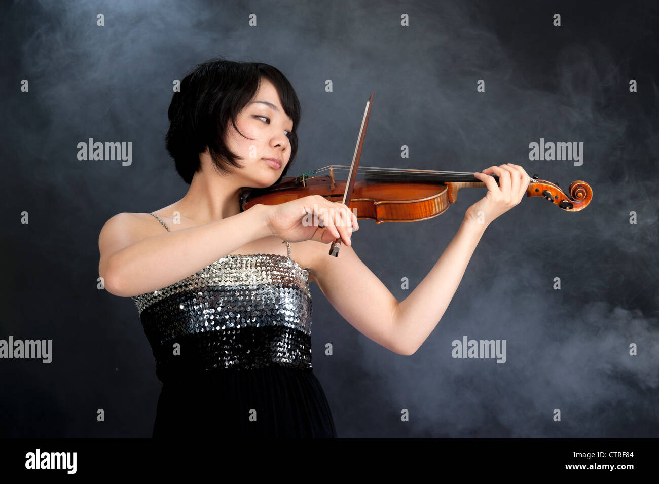female asian violinist on a dark background with smoke Stock Photo Alamy