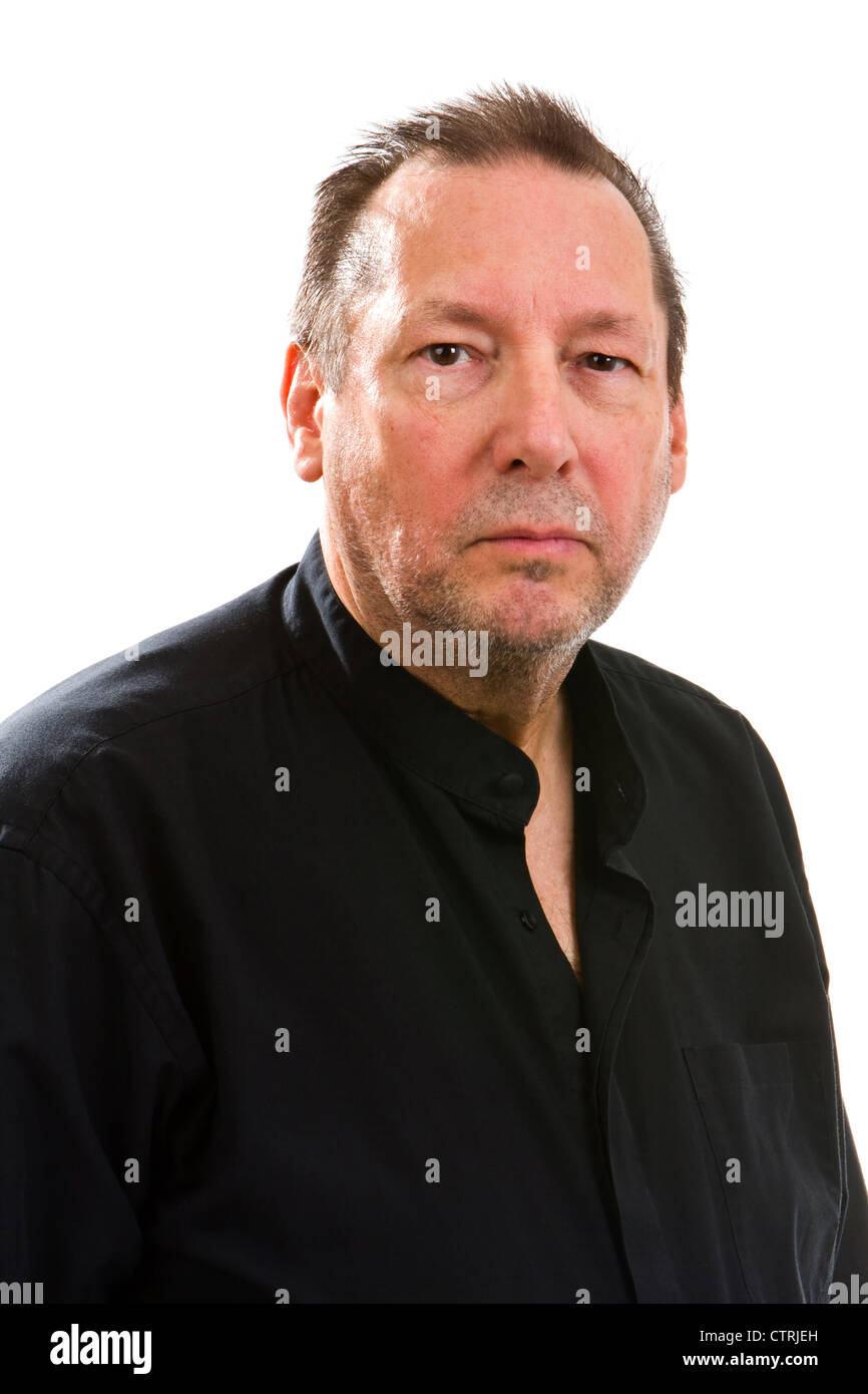 Serious elderly man in a black shirt looks into the camera with a subdued expression. Stock Photo