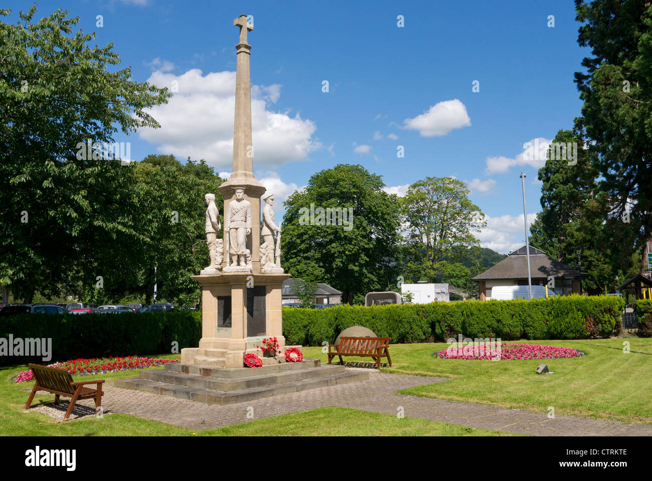 Builth Wells War Memorial garden.  The cross is surrounded by stone figures of a soldier, sailor, airman and a merchant seaman. Stock Photo