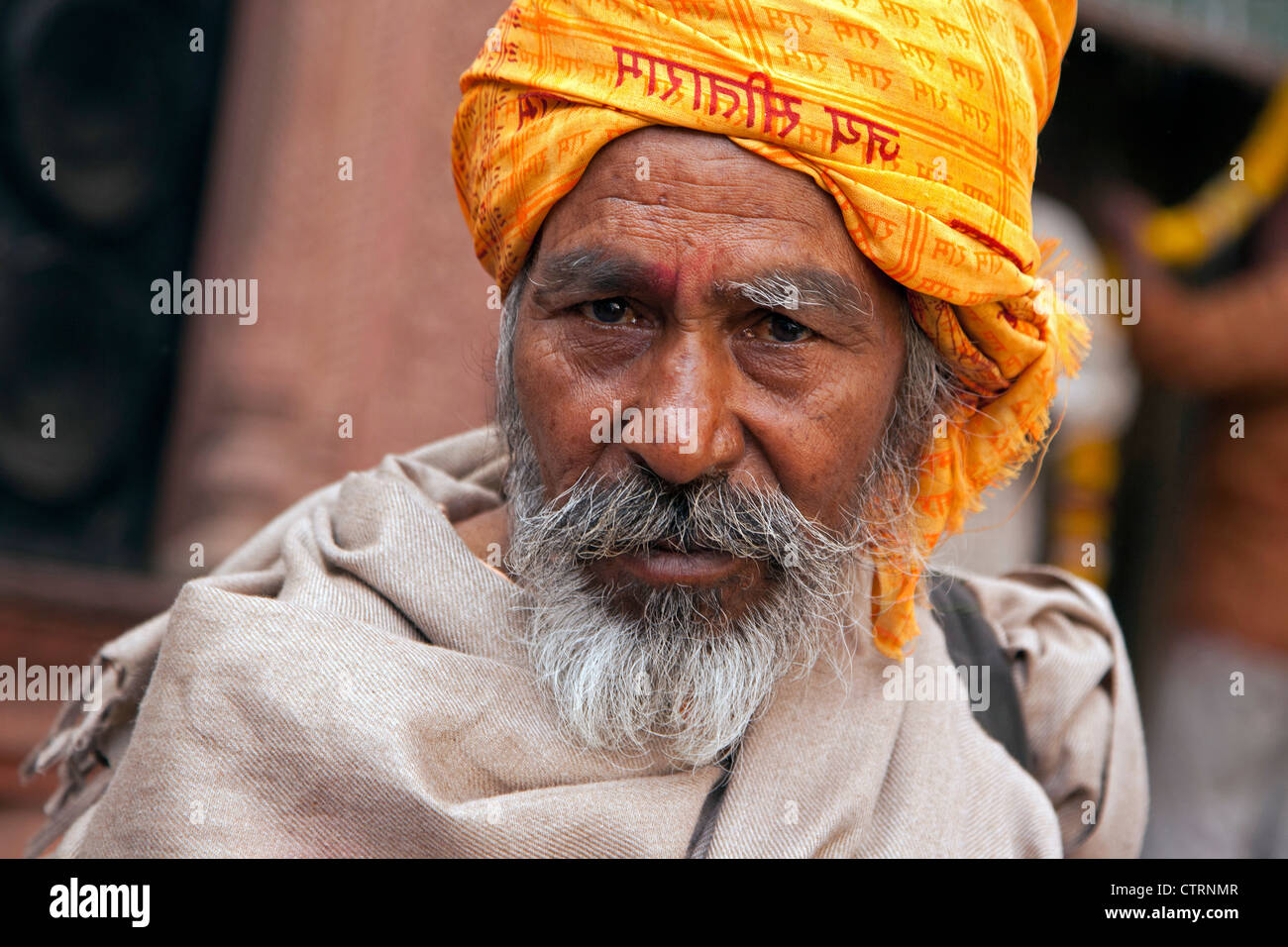 Portrait of Indian follower of the Hare Krishna movement wearing orange turban in Vrindavan, Uttar Pradesh, India Stock Photo