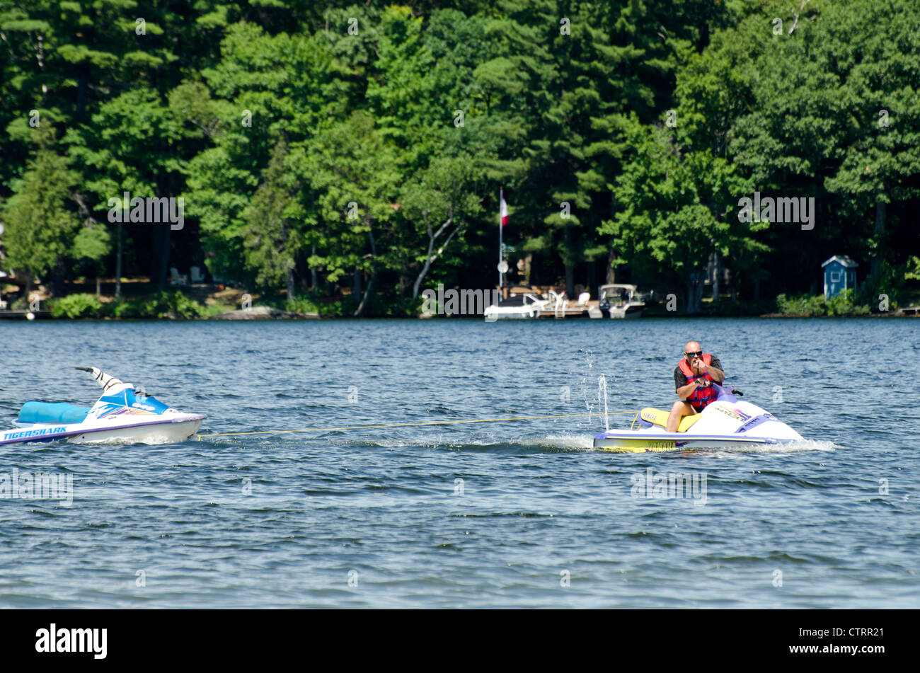 Jet skier towing another jet ski Stock Photo Alamy